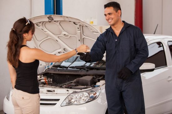 Image of a woman getting her keys back from a mechanic.