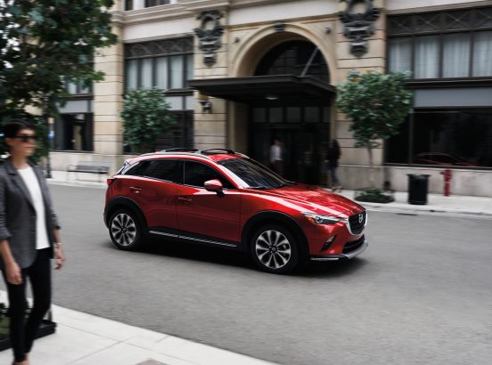 Image of a red 2019 Mazda CX-3 SUV on a city street.