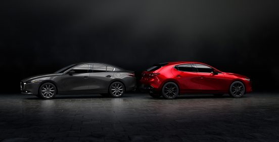 Image of a gray and red 2019 Mazda3 parked back to back in a dark room.